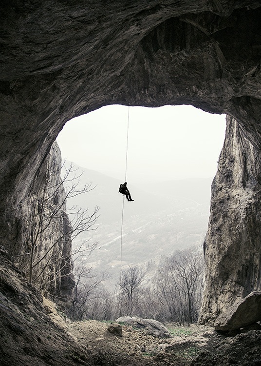 - Beautiful photo showing an abseiling mountaineer from a mountain cave.