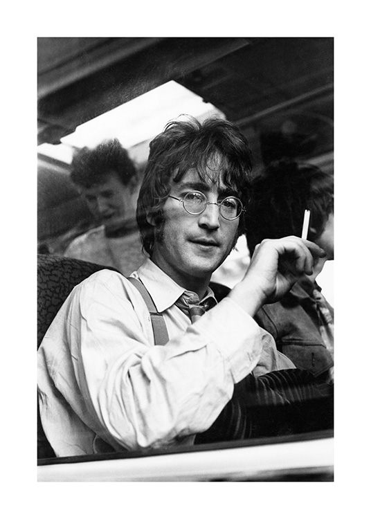  – Black and white photograph of John Lennon on a train, with a cigarette in his hand