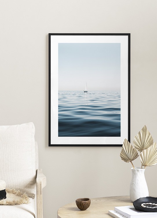  – Photograph of a sailboat in a clear blue ocean with calm waves